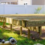 Deck construction work in garden with some torx circular saw, overlooking backyard landscape